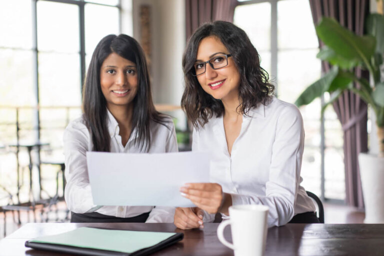 asian-female-coworkers-discussing-document